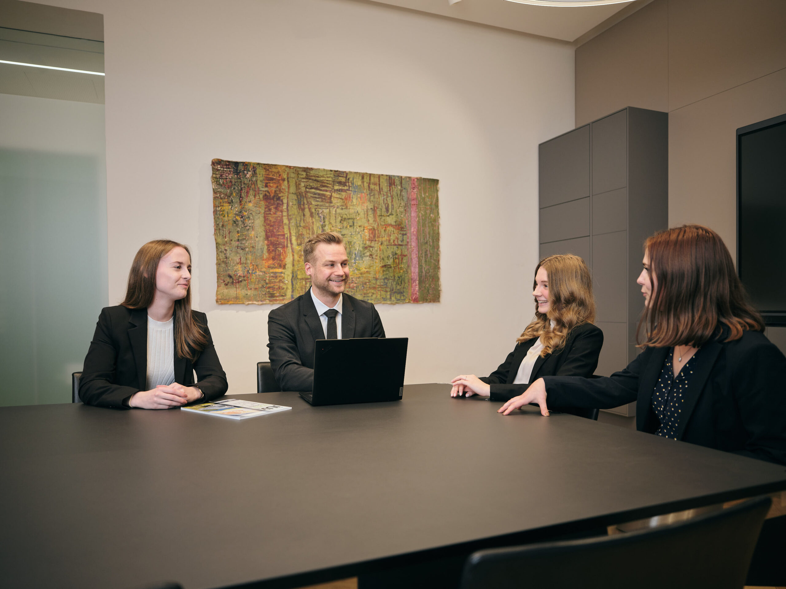 Foto von Unterhaltung zwischen Rechtsanwalt Mag. Gregor Grablowitz, Rechtsanwaltsanwaerterin Mag. Marie-Sophie Götschl, Rechtsanwaltsanwaerterin Mag. Ute Hiebl und Rechtsanwaltsanwaerterin Mag. Jesminne Eisinger in Rechtsanwaltskanzlei in Graz.